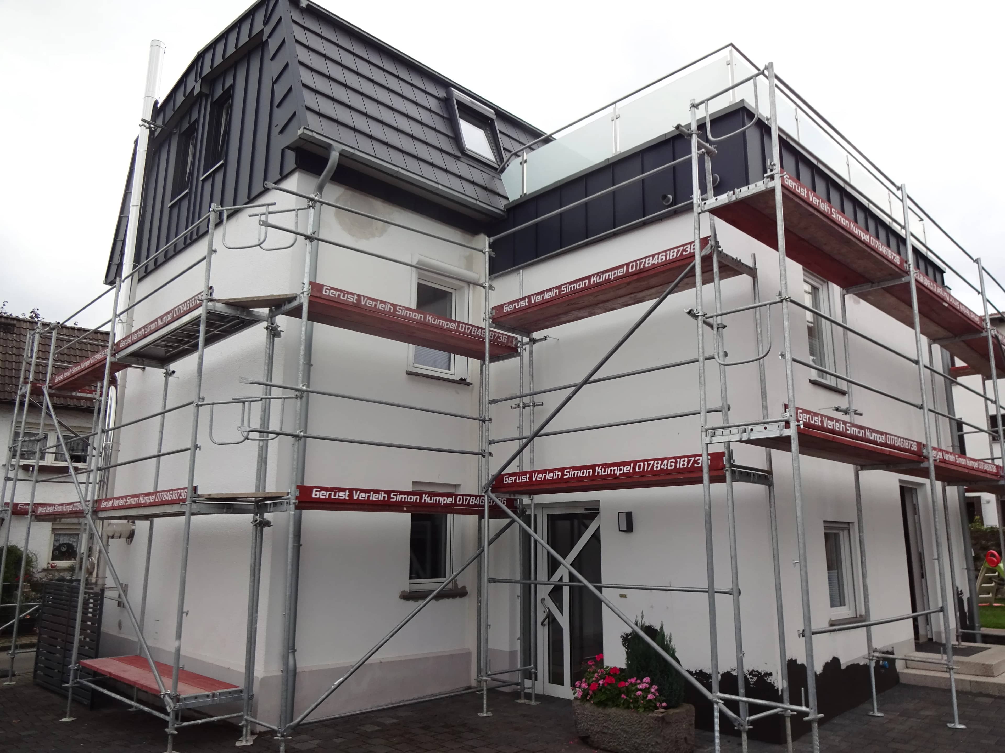 Fassadengerüst rund um ein modernes Einfamilienhaus mit Dachterrasse
